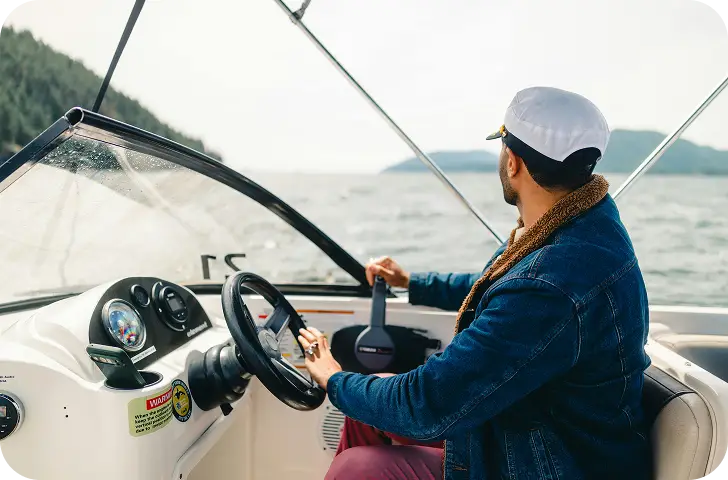 Een jachtkapitein die een modern vaartuig stuurt terwijl hij geniet van een heldere dag op zee.