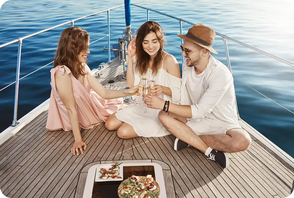 Een groep vrienden die aan boord van een luxe jacht geniet van een drankje en het prachtige uitzicht op de zee.