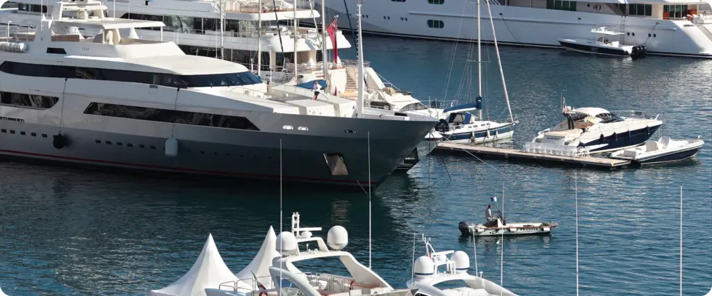 Luchtfoto van premium jachten en boten die zijn aangemeerd in een moderne marina met kristalhelder water.