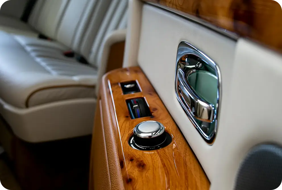 Close-up van het interieur van een luxe voertuig met gepolijste houten accenten, premium materialen en verfijnde ambacht.